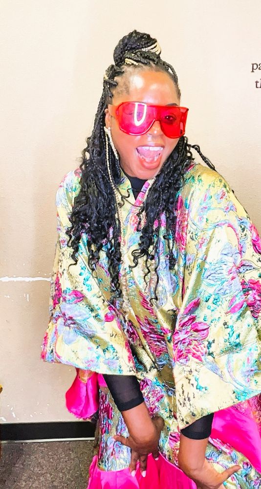 Guest in a colorful outfit and pink shades having fun in the photo booth